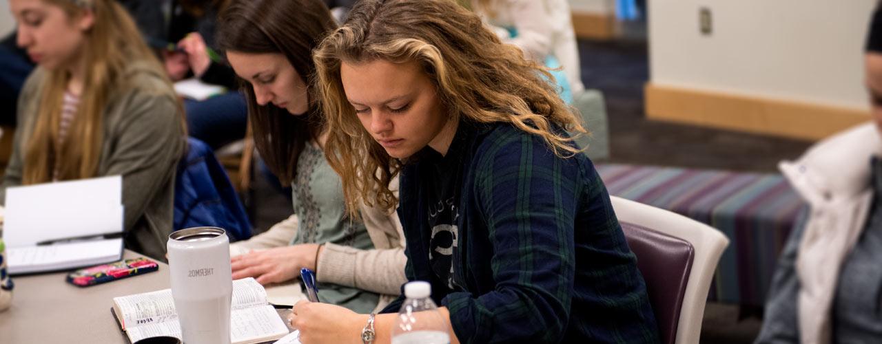 Female student works on an assignment in class